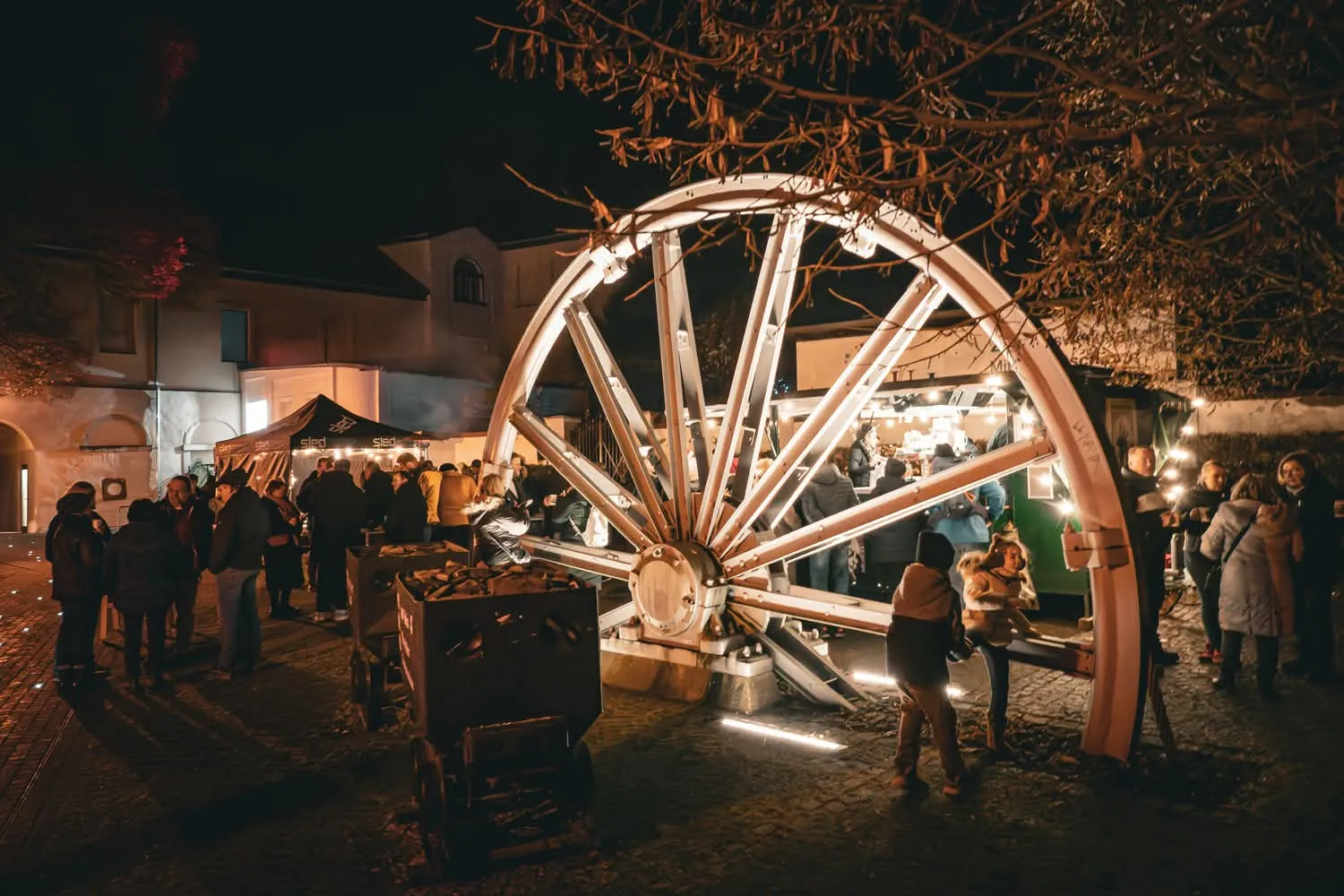 Abendveranstaltung mit beleuchtetem Rad und Getränkeständen
